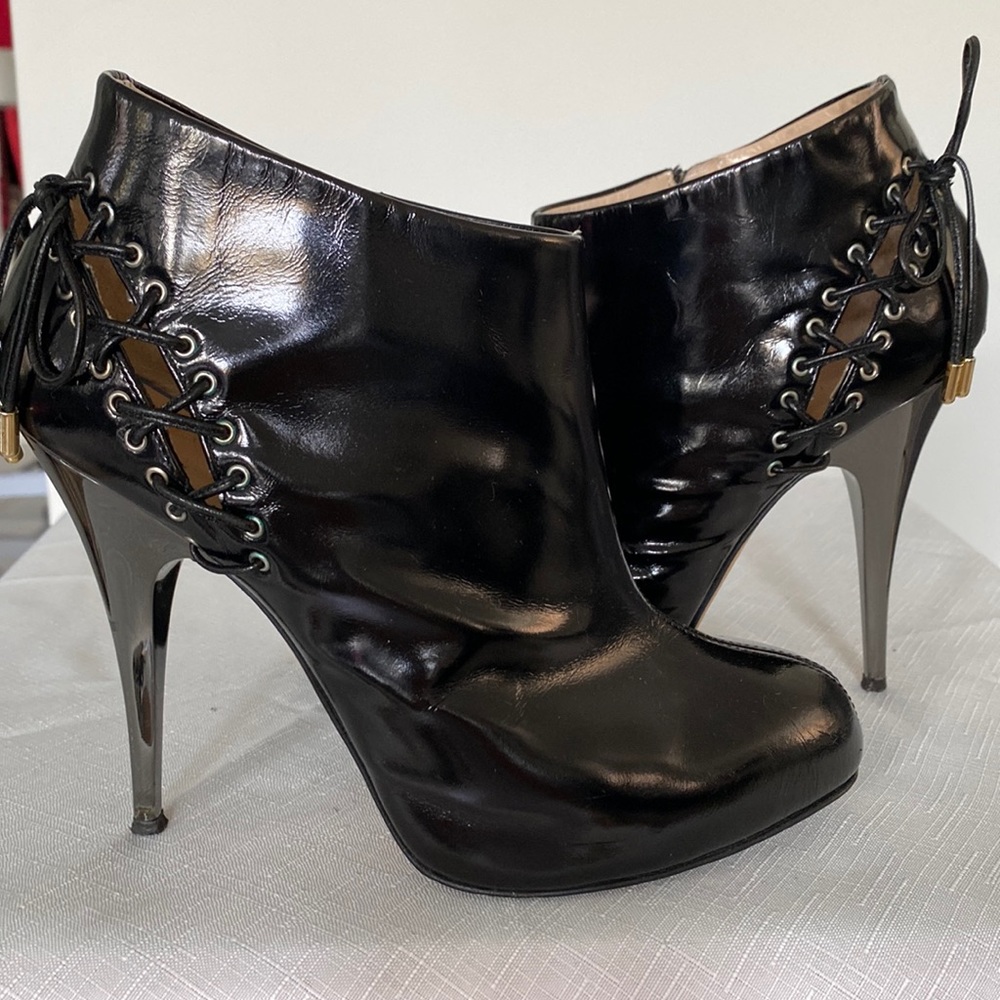 Ankle patent Guuseppe Zanotti boots with leather lace and zipper accent.